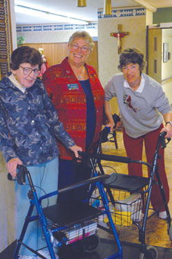 Benedictine Sister Sharon Bierman, center, the eighth administrator of St. Paul Hermitage in Beech Grove, talks with residents Clare Bosler, left, and Jane Marshall, right, on Nov. 17 in the hermitage lobby. (Photo by Mary Ann Wyand)