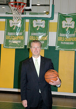 Wearing a jacket and one of his trademark neckties—a gift given to him by one of his teams—coach Joe Etling stands on the court at St. Patrick School in Terre Haute on April 24. Etling is retiring after coaching Irish basketball teams at the school for 17 years. (Photo by Mike Krokos)