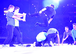 Voluntas Dei Father Leo Patalinghug, who has a third-degree black belt in the martial arts, sails through the air to break a piece of wood with his foot during his keynote address at Lucas Oil Stadium in Indianapolis on Nov. 19 during the National Catholic Youth Conference. (Photo by Natalie Hoefer)