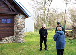 Father Anthony Hollowell, left, and Father Kyle Rodden of the Archdiocese of Indianapolis listen as a member of the Sisters of Providence shares details about the birthplace of St. Theodora Guérin—Indiana’s only saint—in Etables-sur-Mer, France. (Photo by Father Eric Augenstein)