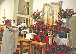 Archbishop Charles C. Thompson incenses an image of Our Lady of Guadalupe on Dec. 12 at St. Gabriel the Archangel Church in Indianapolis during a Mass on the feast of Our Lady of Guadalupe. (Photo by Sean Gallagher)