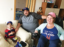 Russ and Katrina Kelly, members of St. Mary Parish in Indianapolis, pose with their adopted son, 5-year-old Gosho, at his orphanage in Bulgaria last October. The 5-year-old boy shares the same condition as his adoptive mother—spinal muscular atrophy. (Submitted photo)