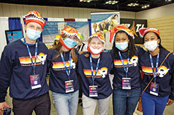 Youths from Our Lady of the Most Holy Rosary Parish in Indianapolis pose for a photo in the Interactive Village of the National Catholic Youth Conference in Indianapolis on Nov. 18. Roch Egan, left, Kierra Wilson, Moire Roller, Mataya Watson and Elianna Watson are all wearing the NCYC sweatshirt for the Archdiocese of Indianapolis. (Photo by John Shaughnessy)