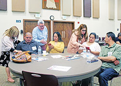 Detrás de sus alumnos, los facilitadores del curso de planificación familiar natural (PFN), Georgina Villaseñor (izquierda), Ernesto Villaseñor y Mireya Ramírez, instruyen a José Pérez (izquierda), Carolina Pérez, María García y Alberto Ambrosio durante el primer curso de planificación familiar natural en español de la Arquidiócesis en la Parroquia de Nuestra Señora de Greenwood en abril. (Foto enviada)