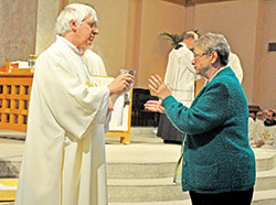 Deacon Richard Cooper of St. Mary Parish in Lanesville offers the precious blood in Communion on March 31, 2015, in SS. Peter and Paul Cathedral in Indianapolis during the annual archdiocesan chrism Mass. (Criterion file photo by Sean Gallagher)