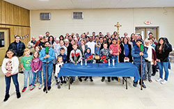 Father Jeyaseelan Sengolraj, administrator of St. Michael Parish in Charlestown and St. Francis Xavier Parish in Henryville, center, smiles with members of St. Michael after an outdoor, bilingual rosary procession held at the parish on Oct. 30. (Submitted photo)