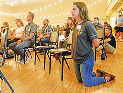 Meagan Morrisey, director of the archdiocesan Office of Young Adult and College Campus Ministry, and other young adult Catholics pray during a holy hour of eucharistic adoration on July 12 during a Theology on Tap event at McGowan Hall in Indianapolis. (Photos by Sean Gallagher)