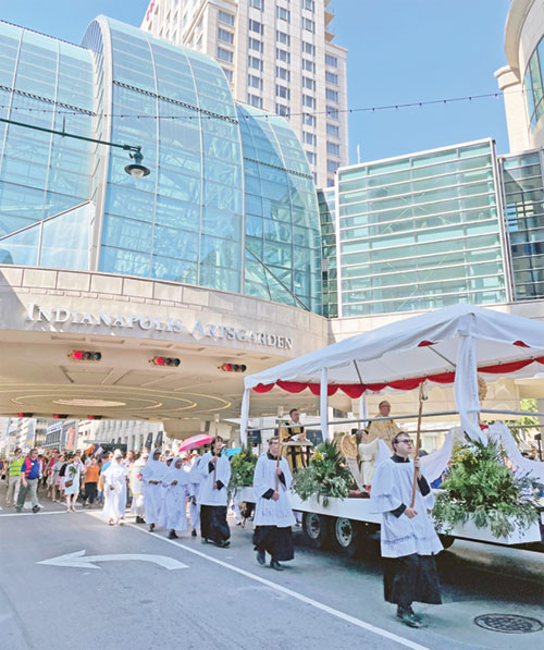 Catholics from across central and southern Indiana follow a float carrying the Blessed Sacrament during a June 19, 2022, eucharistic procession on Illinois Street in downtown Indianapolis. The procession was part of the start of the National Eucharistic Revival in the archdiocese. (Photo courtesy of Cantaloupe.tv)