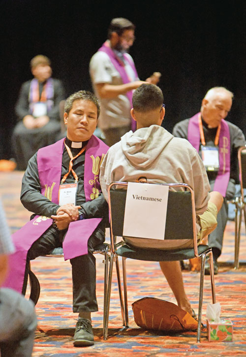 A priest hears a confession on July 17 in the Indiana Convention Center during the National Eucharistic Congress in Indianapolis. (File photo by Sean Gallagher)